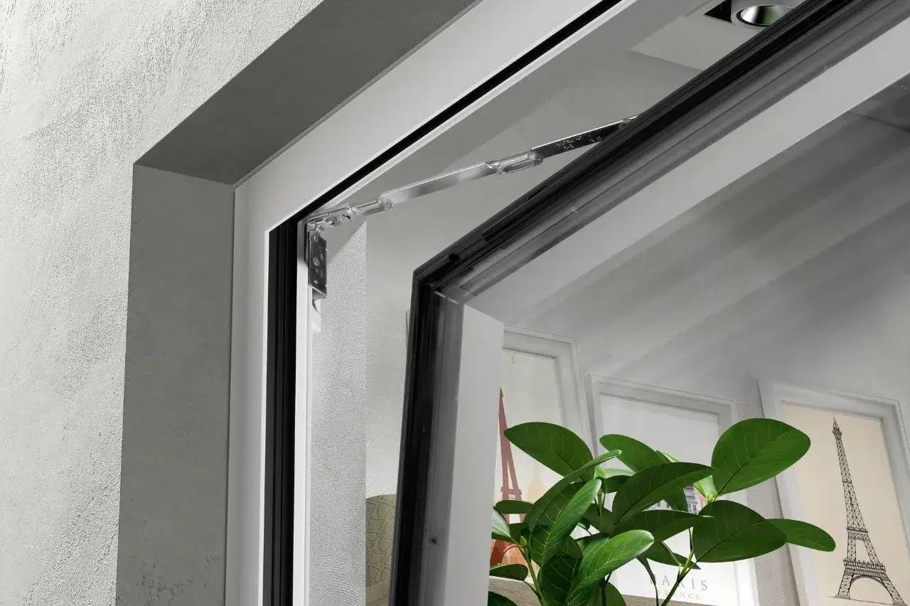 Vue en gros plan d'une fenêtre moderne basculante, partiellement ouverte, avec une plante verte à l'intérieur et des affiches en arrière-plan