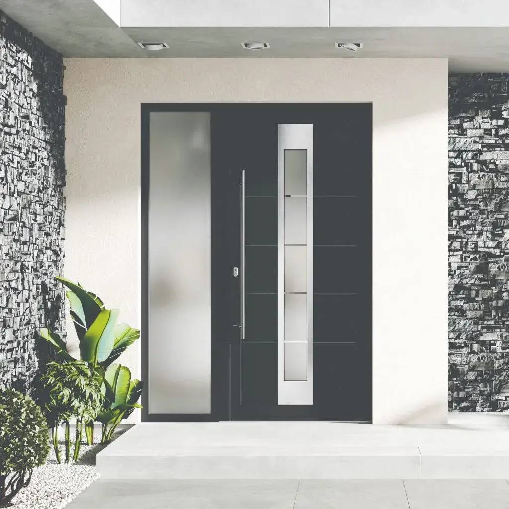 Porte d'entrée moderne noir et argent avec vitrage, encadrée de murs en pierre texturée et accompagnée de plantes vertes.