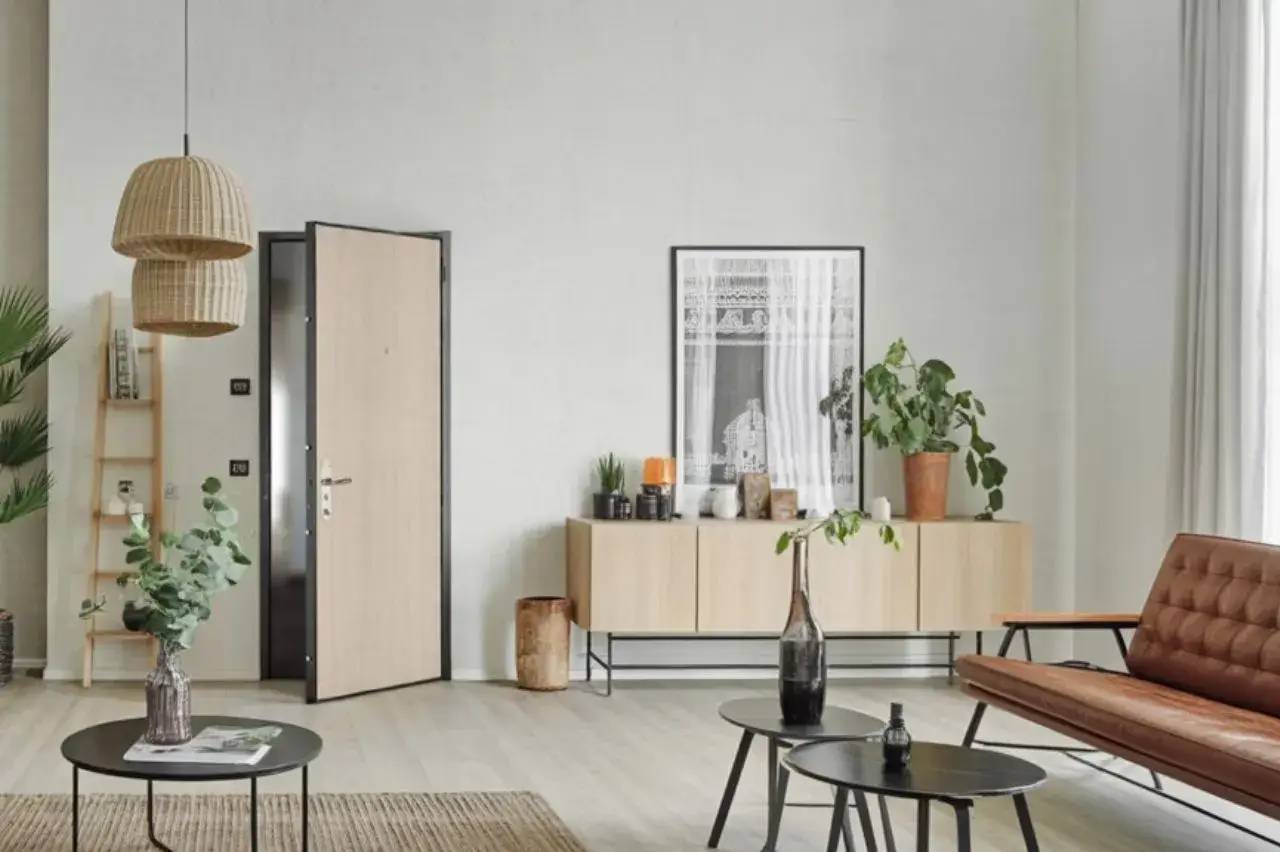 Un intérieur moderne et minimaliste avec des meubles en bois clair, des plantes vertes et une décoration épurée.