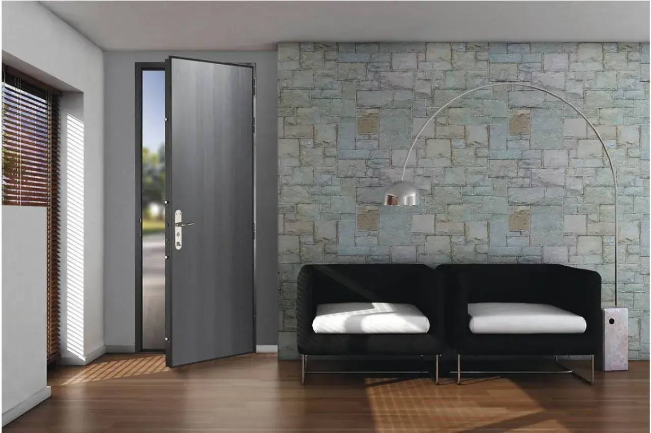 Un intérieur moderne avec un mur en pierre, un canapé noir, une lampe arquée et une porte entrouverte sur une terrasse lumineuse.