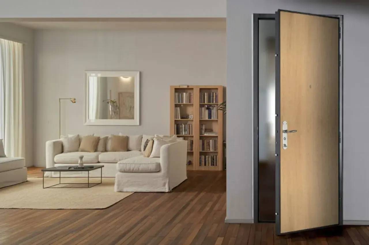 Un salon élégant et moderne avec un canapé blanc, une bibliothèque, et une porte en bois ouverte, offrant une ambiance chaleureuse et accueillante.