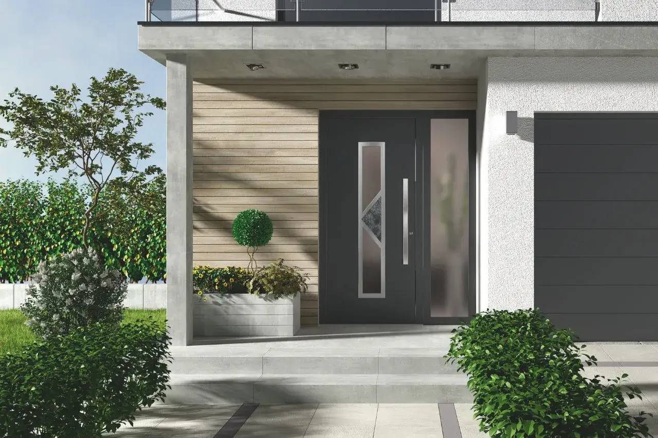 Entrée moderne de maison avec porte grise vitrée, encadrée de plantes et d'une façade en bois clair.