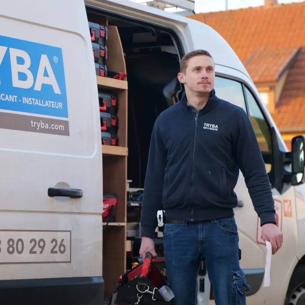Un homme en tenue de travail se tient devant un fourgon de service TRYBA, porte ouverte, rempli d'outils et d'équipements.