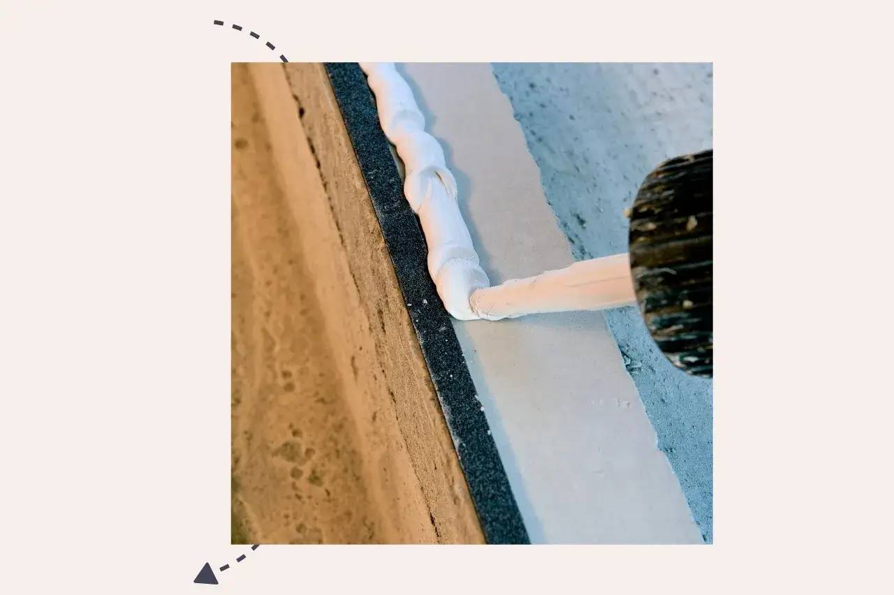 Application de mastic blanc sur une surface à l'aide d'un pistolet extrudeur.