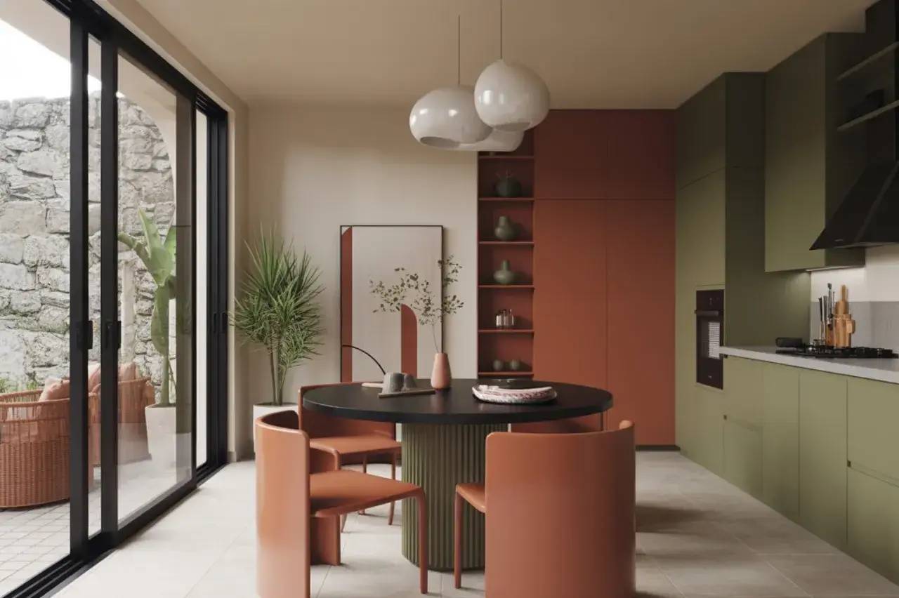 Cette image montre une cuisine moderne et élégante avec des tons terre cuite et vert olive, mettant en valeur un mobilier design et de grandes fenêtres vitr