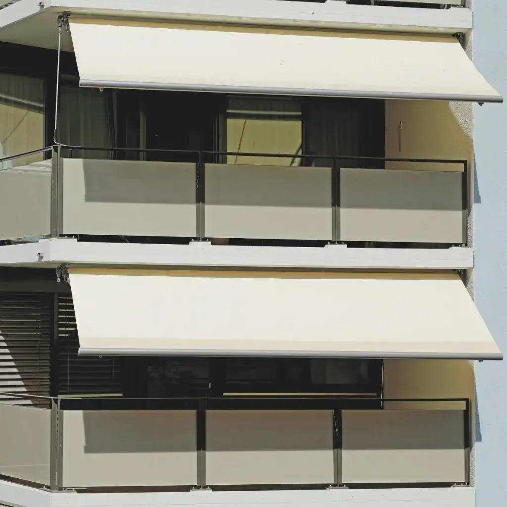 Deux balcons modernes avec garde-corps en verre et stores beige.