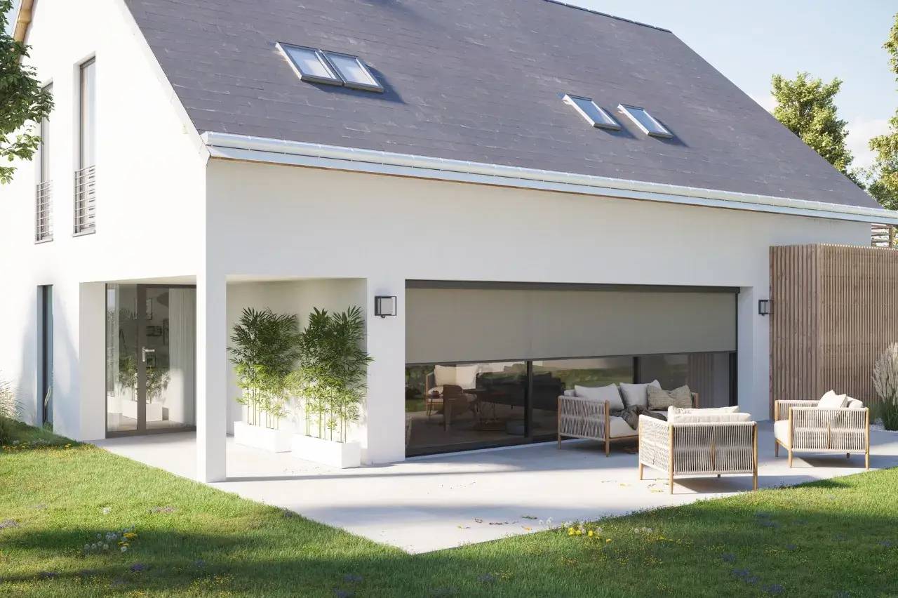 Maison moderne blanche avec un grand jardin et terrasse aménagée, baignée de lumière naturelle.