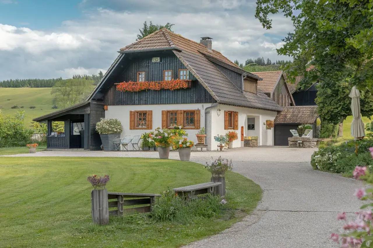 Cette charmante maison de campagne, entourée de verdure et ornée de fleurs colorées, offre un cadre paisible et pittoresque.