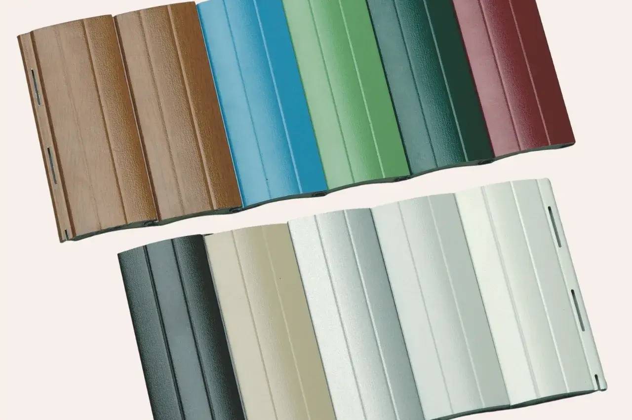 L'image montre plusieurs échantillons de bardage extérieur en métal de différentes couleurs et textures.