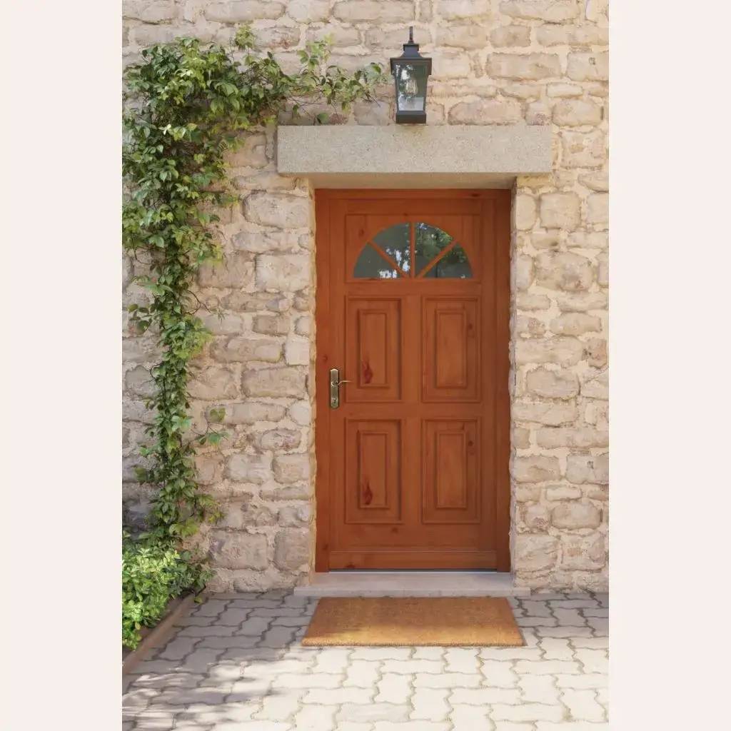 Une porte en bois chaud avec un demi-cercle vitré, encadrée de pierre et de vigne grimpante, surmontée