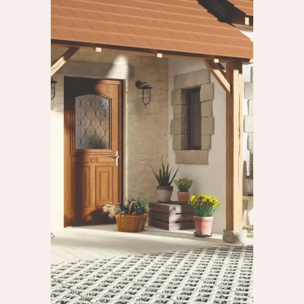 Une entrée accueillante en bois avec des plantes en pot et une lumière extérieure fixée au mur en pierre.