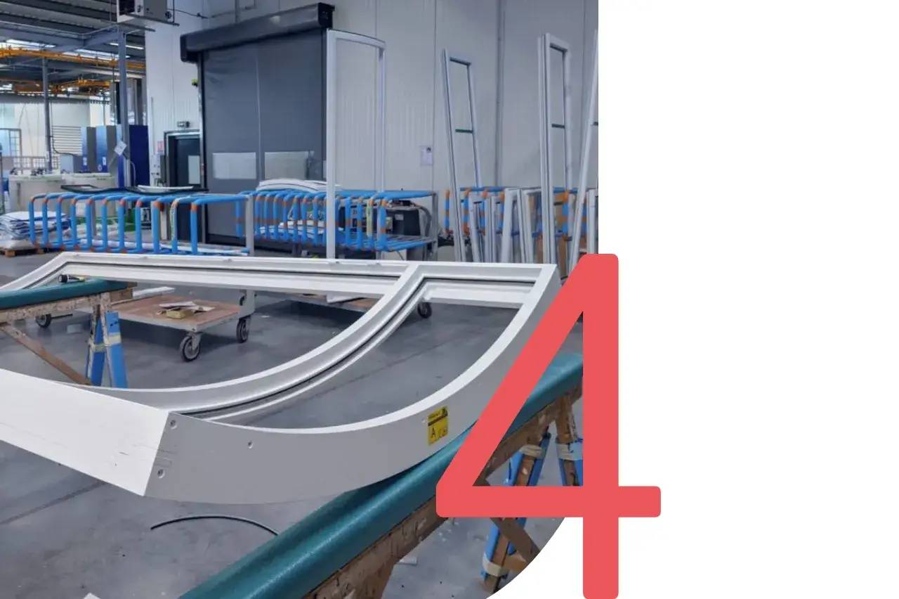 L'image montre des cadres métalliques arqués dans un atelier, avec le chiffre quatre en rouge sur le côté droit.