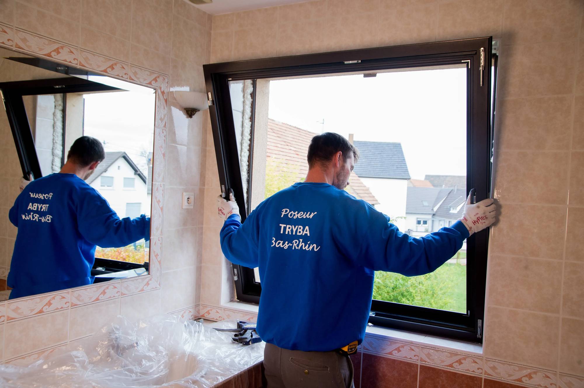 Un installateur de fenêtres Tryba travaille dans une salle de bain.