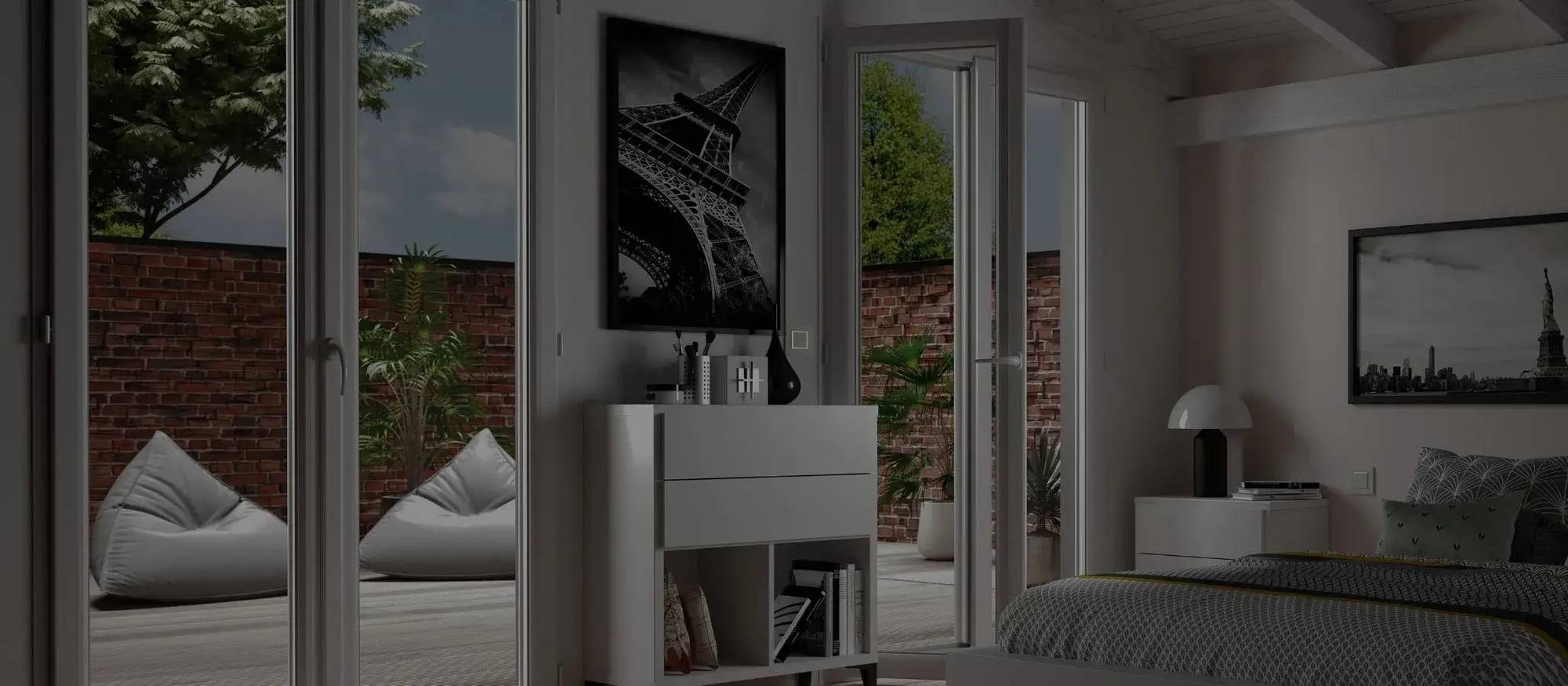 Une chambre moderne et élégante avec des portes vitrées ouvertes sur une terrasse, décorée de coussins et d'œuvres d'art en noir et