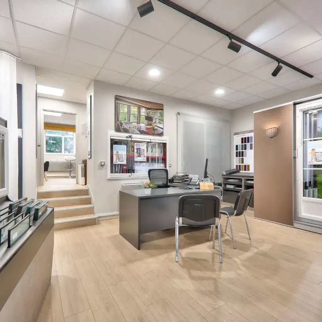 Un bureau moderne et lumineux avec un mobilier élégant, des échantillons de couleurs aux murs et une atmosphère professionnelle.