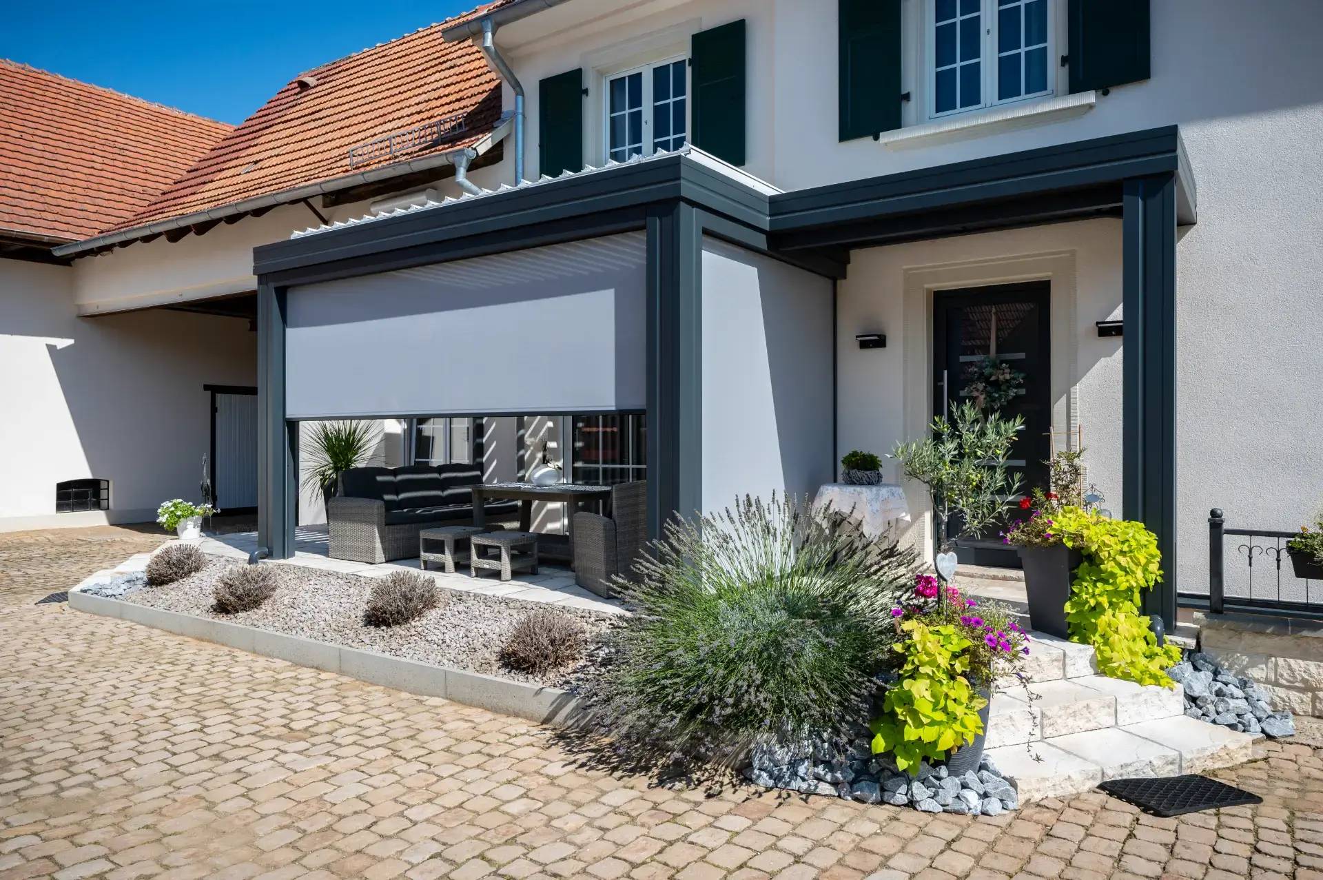 Salon de jardin et porte d'entrée sous Pergolas à storescreen