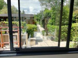 Vue depuis une véranda moderne donnant sur un jardin paisible