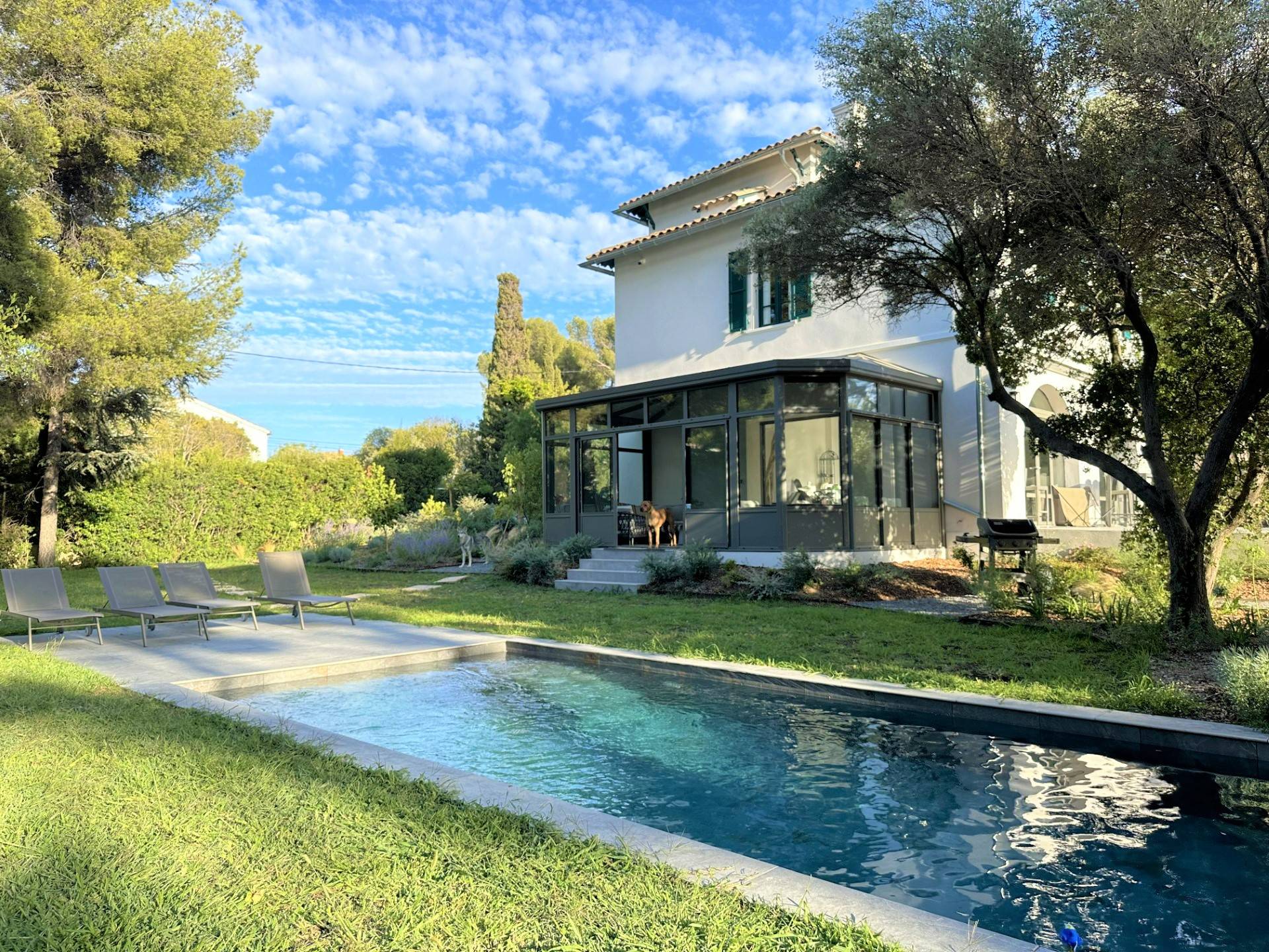 Véranda élégante en verre à côté d'une piscine accueillante