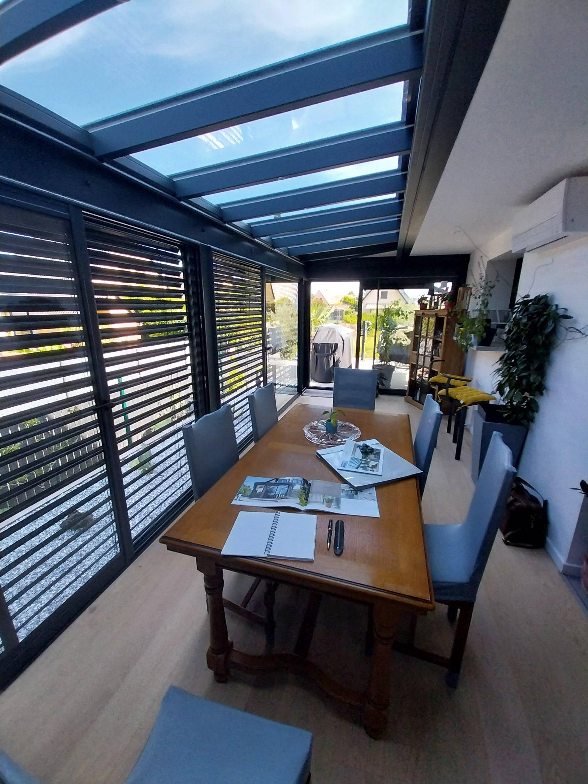 Véranda moderne avec toit en verre et mobilier élégant