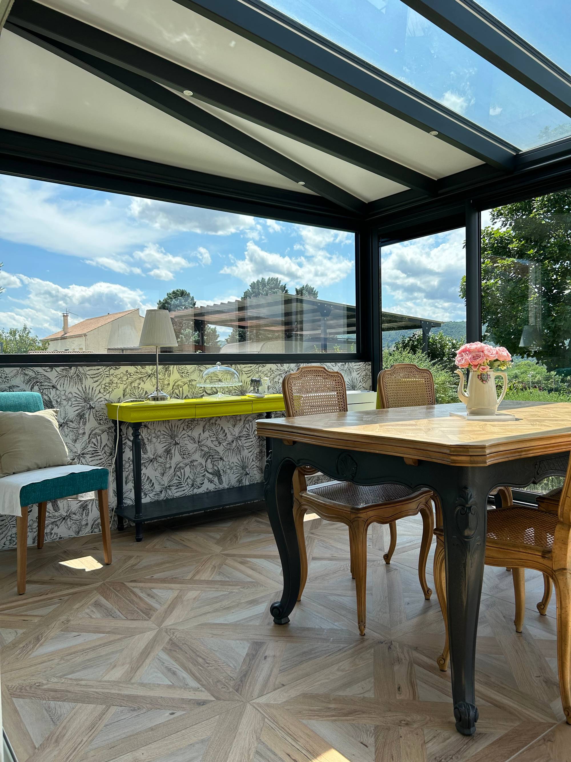 Véranda lumineuse avec toit en verre et mobilier élégant